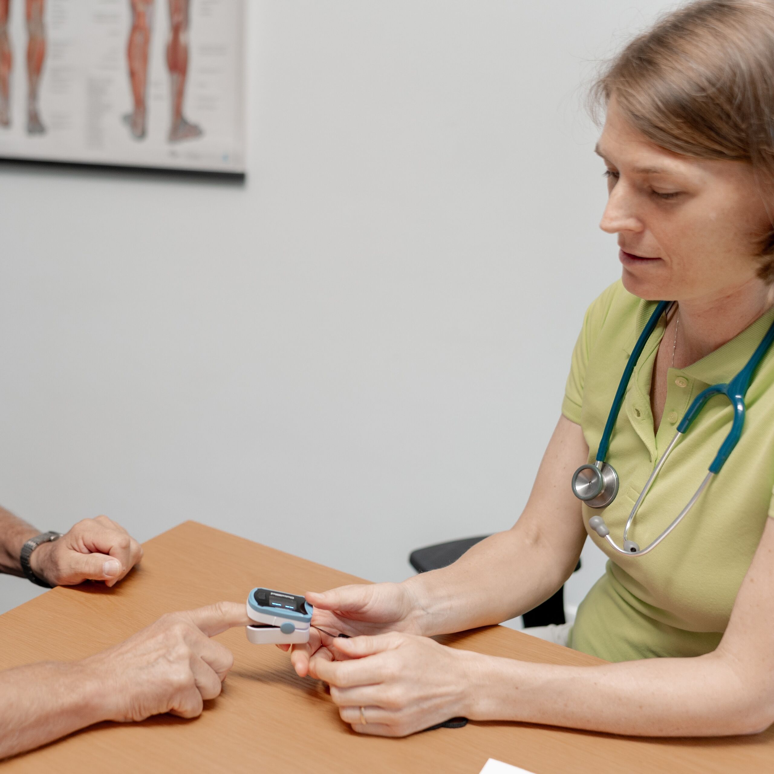 Ärztin misst den Puls eines älteren Patienten